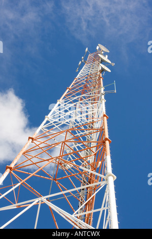 Communications en treillis rouge et blanc mât avec fond de ciel bleu Banque D'Images