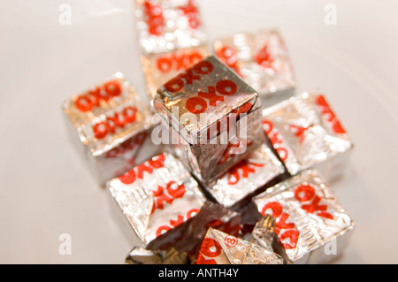 Pile de l'argent enveloppé dans du papier de bouillon de bœuf OXO cubes on plate Banque D'Images