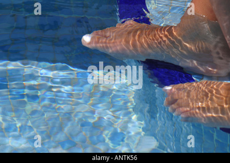 Les femmes se reposant les pieds et les orteils dans la piscine Banque D'Images