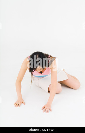 Jeune femme agenouillée sur le plancher Banque D'Images