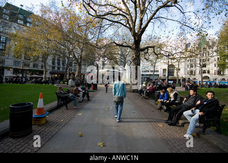 Leicester square personnes siègent dans les bancs Londres Banque D'Images