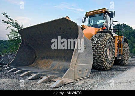 Grande roue du chargeur avec des chaînes de pneu dans une carrière Banque D'Images