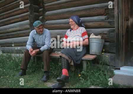 Vieux couple fermier la conversation à la fin de la journée, assis sur un banc, de la Lituanie, de Aukstaitija Banque D'Images