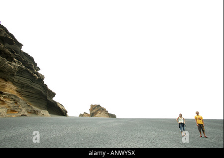 Jeune couple standing at a beach sur Lanzarote, Canaries Banque D'Images