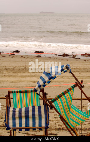 Chaises longues sur les plages de sable à shanklin de Sandown, sur l'île de Wight d'être renversés par les vents violents et la pluie sur un terrain désertique Banque D'Images