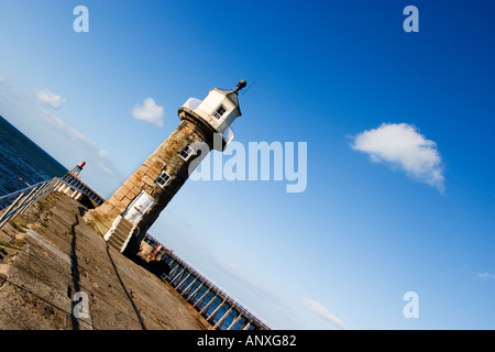 Le phare de la jetée Est 1854 encadré par trois nuages blancs sur un ciel bleu à Whitby, North Yorkshire Angleterre Banque D'Images