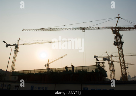 Coucher de soleil sur un des sites de construction grues dans Beijing Chine Banque D'Images