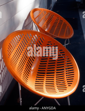 Retro des chaises en plastique de couleur orange frappante (couleur) Banque D'Images