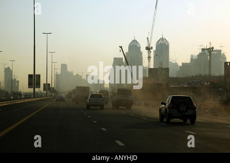 Les voitures qui circulent le long de l'autoroute avec des immeubles de grande hauteur en construction, DUBAÏ, ÉMIRATS ARABES UNIS Banque D'Images