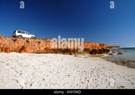 Véhicule 4X4 garé sur rochers rouges à côté de la plage 3 Mile Zone Sanctuaire Ningaloo Reef Marine Park Australie Occidentale Aucun PR Banque D'Images