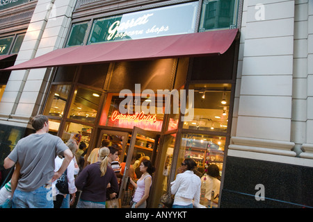 L'ILLINOIS Chicago personnes attendent en ligne pour entrer Garretts popcorn store boutique de vente au détail au centre-ville bondé soir Banque D'Images