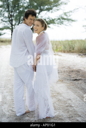 Bride and Groom walking on sand Banque D'Images