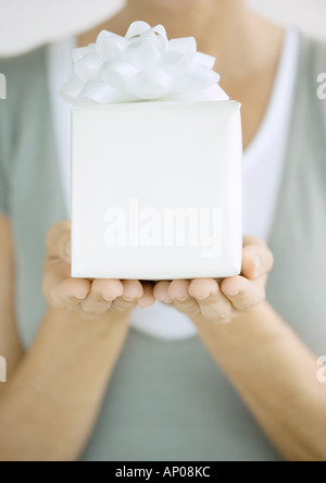 Woman holding up présent Banque D'Images