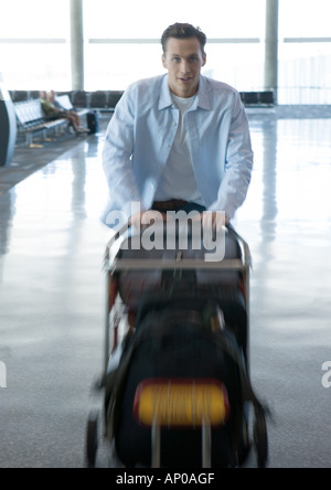 Man pushing chariot à bagages dans l'aéroport Banque D'Images