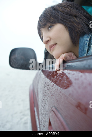 Portrait tête hors de la fenêtre de voiture par temps de pluie Banque D'Images