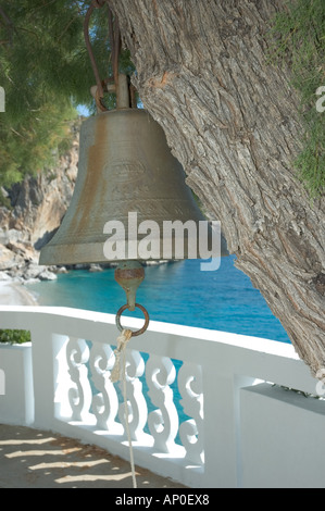 L'Europe, Grèce, Karpathos, Kyra Panagia : cloche de l'église hanging in tree et Kyra Panagia chapelle surplombant la plage Banque D'Images