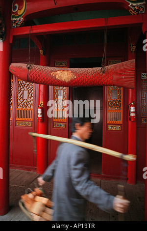 Porter avec des matériaux de construction en bois et de poissons en face de Qiyuan monastère, Jiuhuashan, Anhui Province, China, Asia Banque D'Images