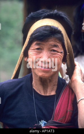 Les femmes des tribus Apatani en Arunachal Pradesh, Inde,transporter de lourdes charges dans des paniers suspendus de leur tête ronde Banque D'Images