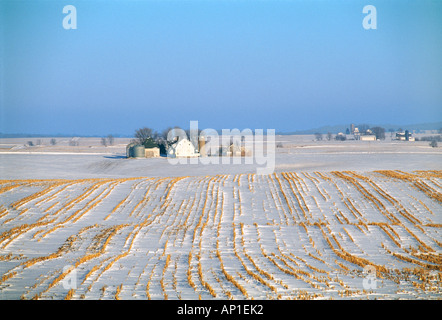 Le domaine de la chaume de maïs avec des fermes à l'arrière-plan et l'hiver la neige couvrant la campagne / New York, USA. Banque D'Images