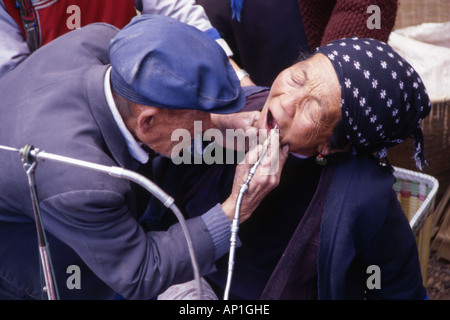 Dentiste local travaillant sur un marché local en forme de dents de womans Yunnan province chine Banque D'Images