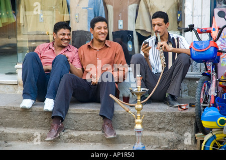 Les jeunes hommes partageant une conduite d'eau et de sourire, dans la zone de marché d'Assouan, Egypte, Moyen-Orient. DSC 4287 Banque D'Images