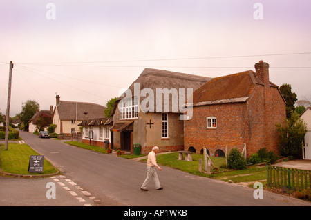Un homme traverse LA ROUTE À L'ÉPICERIE DU VILLAGE ET BUREAU DE POSTE À BRIANTSPUDDLE DANS LE DORSET UK Banque D'Images
