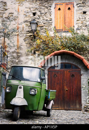 Un vieux camion à trois roues à plat vert dans une rue latérale dans la ville italienne de Molini di Triora, Italie du Nord Banque D'Images