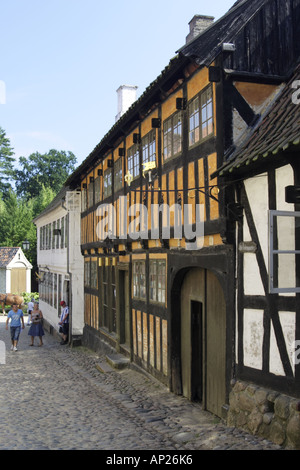 Rue Pavée avec orange bâtiment à colombages dans la vieille ville Museum Den Gamle By, Arhus DANEMARK Banque D'Images