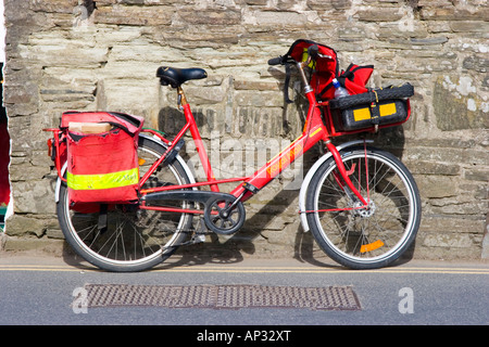 Postman s location appuyé contre un mur de jardin Banque D'Images