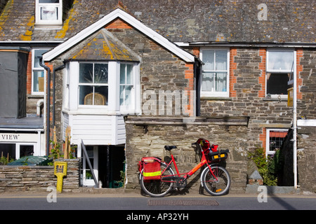 Postman s location appuyé contre un mur de jardin Banque D'Images