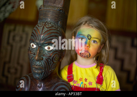 Fille avec facepainting (comme un moko maori, Tatoo), sculpture Maori en Marae, célébrations à Waitangi Day, Okains Bay Mus Banque D'Images