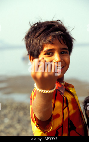 Jeune enfant indien de rue secouant poing à la caméra, Mumbai, Inde du Sud Banque D'Images