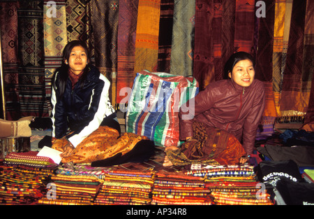 Deux jolies marchands de stalle de marché de femmes vendant des tissus, foulards, broderie, Luang Prabang, Laos Banque D'Images