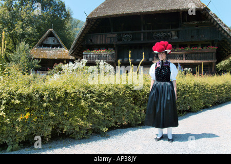 Femme en costume traditionnel de la Forêt Noire, en face de Farmhouse Banque D'Images