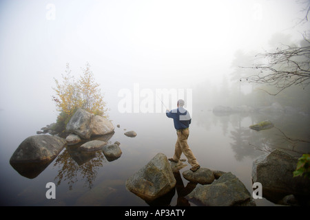 Pêche à la mouche dans l'homme la lumière du matin sur le lac de Millinocket, Maine, États-Unis d'Amérique, USA Banque D'Images