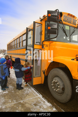 Les élèves des écoles primaires boarding school bus sur un jour d'hiver à Edmonton Alberta Canada Banque D'Images