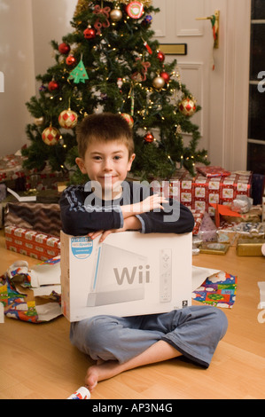 Ouverture garçon présente en vertu de l'arbre le matin de Noël Banque D'Images