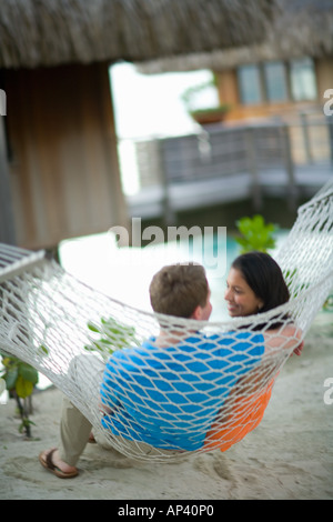 Couple sur hamac, Bora Bora Nui Resort & Spa, l'île de Bora Bora, îles de la société, Polynésie Française, Pacifique Sud. (MR) Banque D'Images