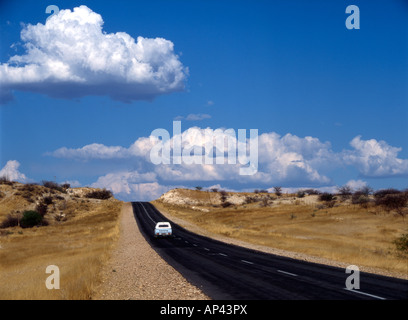 Une camionnette voyage le long d'une route goudronnée dans la distance en Namibie Banque D'Images