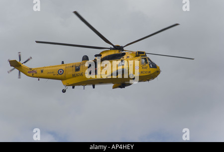 Un membre d'équipage est à la recherche d'un hélicoptère de sauvetage de la RAF jaune qu'il plane au-dessus de la rivière Crouch Banque D'Images