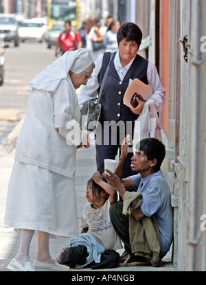 Une religieuse donne l'aumône à un mendiant dans une rue de Oaxaca, Mexique Banque D'Images