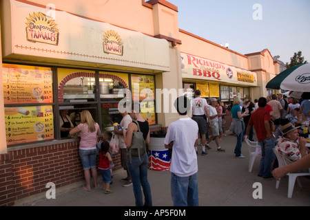 Le soleil se couche et c'est l'heure du dîner. Les gens font leurs choix alimentaires, l'achat, puis en essayant de trouver une table pour manger. Banque D'Images