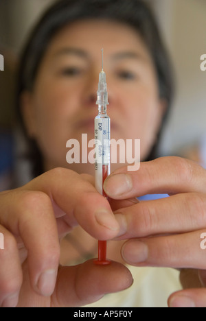 Femme la préparation d'une dose d'Interféron pour l'auto-administration par aiguille hypodermique Banque D'Images