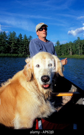 La liberté, NH un homme et son chien à bord de canots étang à truites dans la région des lacs du New Hampshire. Une partie de l'avenir des forêts de la ville. (MR) Banque D'Images