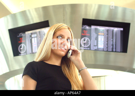 Jeune femme businesswoman talking on cell phone at airport Banque D'Images