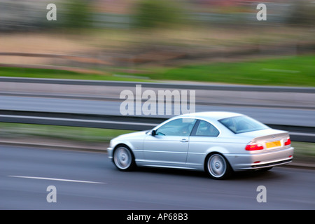 Jour Coupé BMW de Série 3 automobile voiture vitesse fast motion blur sur autoroute autoroute Angleterre Royaume-Uni Grande-Bretagne Banque D'Images