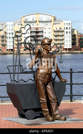 La sculpture aux mineurs de charbon gallois par artiste John Clinch de Cardiff Bay en face de bloc d'appartement Pays de Galles UK GO Banque D'Images