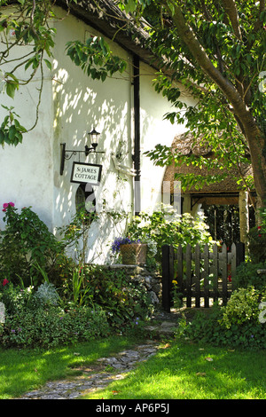 English Chalet jardin à la Milton Abbas Dorset avec une petite barrière en bois et la porte ronde roses Banque D'Images