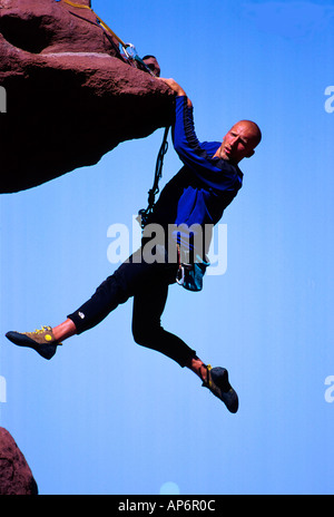 Rock climber hanging from falaise dans Fisher Towers, Voie navigable de la rivière Colorado près de Castle Valley dans la région de Moab, Utah, USA Banque D'Images