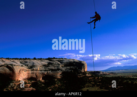 L'homme de la descente en rappel sur corde dans paysage de Fisher Towers, en voie navigable de la rivière Colorado près de Castle Valley, Moab, Utah, USA Banque D'Images